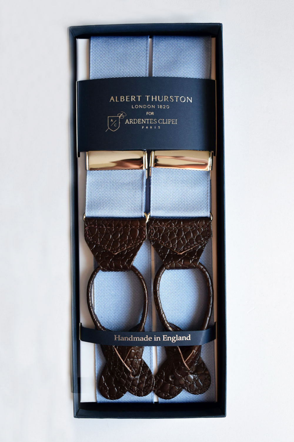 Blue sky suspenders by Albert Thurston with Ardentes Clipei branding, featuring adjustable straps and classic design.