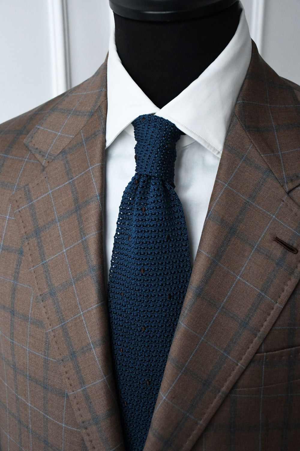Blue petrol knit tie with dark brown polka dots by Ardentes Clipi, shown on a white background.