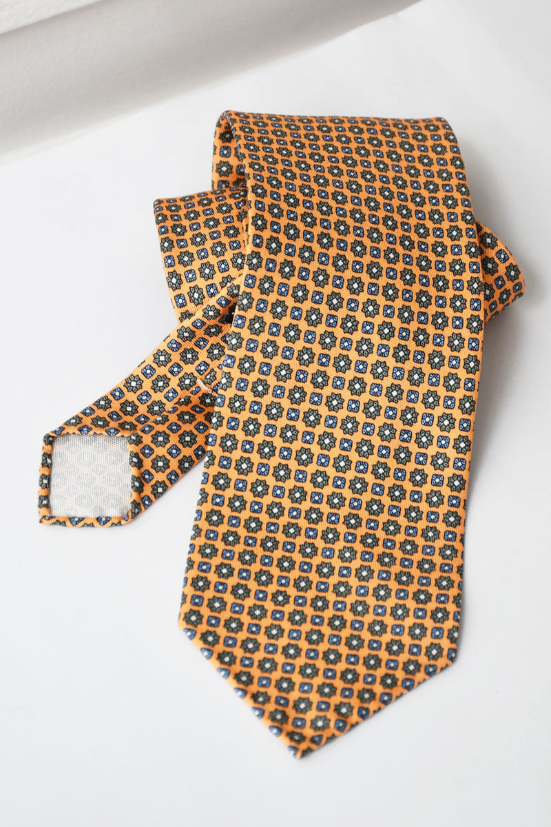 Orange pastel floral motif necktie by Ardentes Clipei, showcasing a vibrant, elegant design ideal for formal occasions.