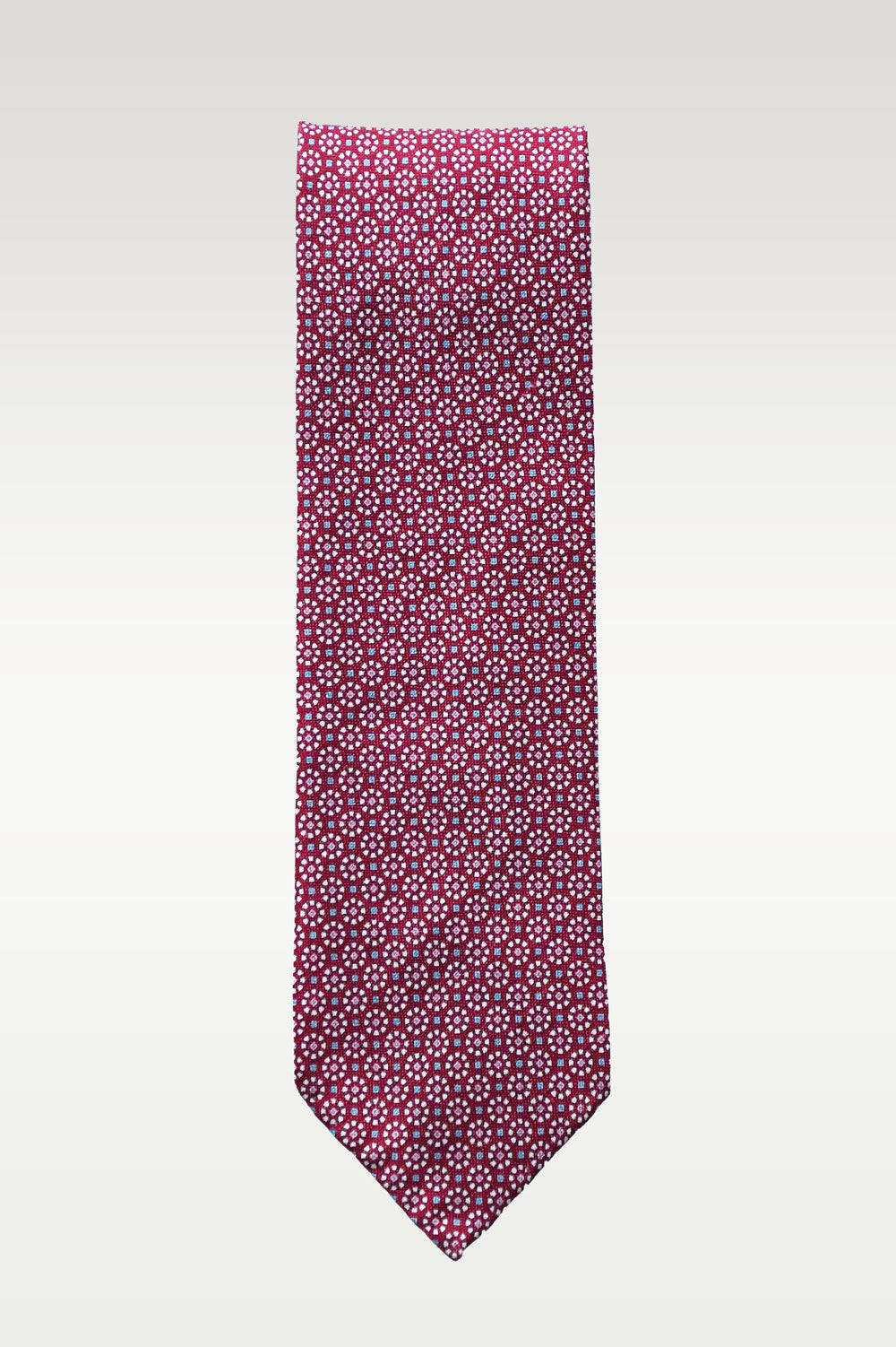 Red raspberry-colored tie with geometric pattern, made of silk and linen, by Ardentes Clipei, featuring intricate design details.