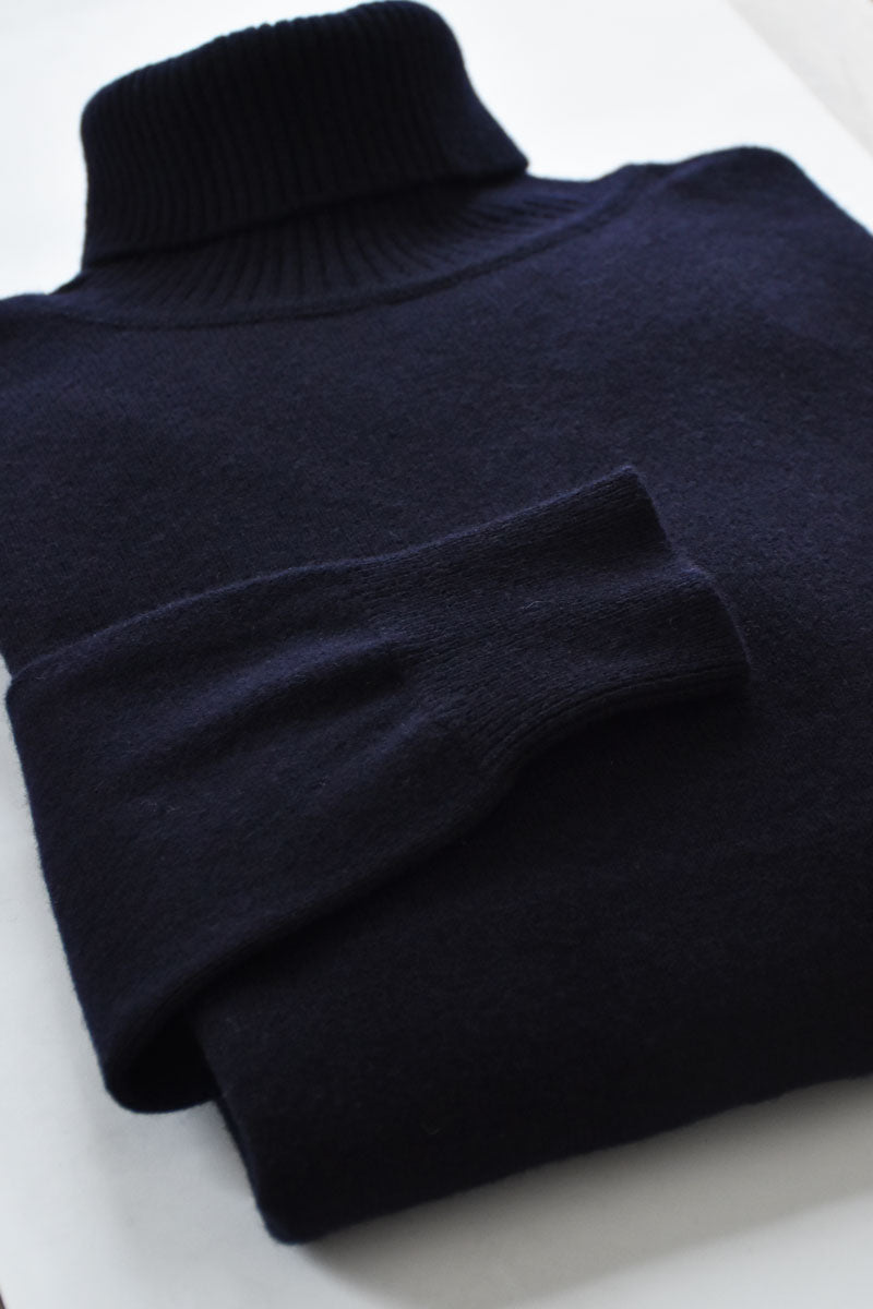 Blue navy lambswool turtleneck sweater by Ardentes Clipei, close-up showing soft knit texture and classic collar design.