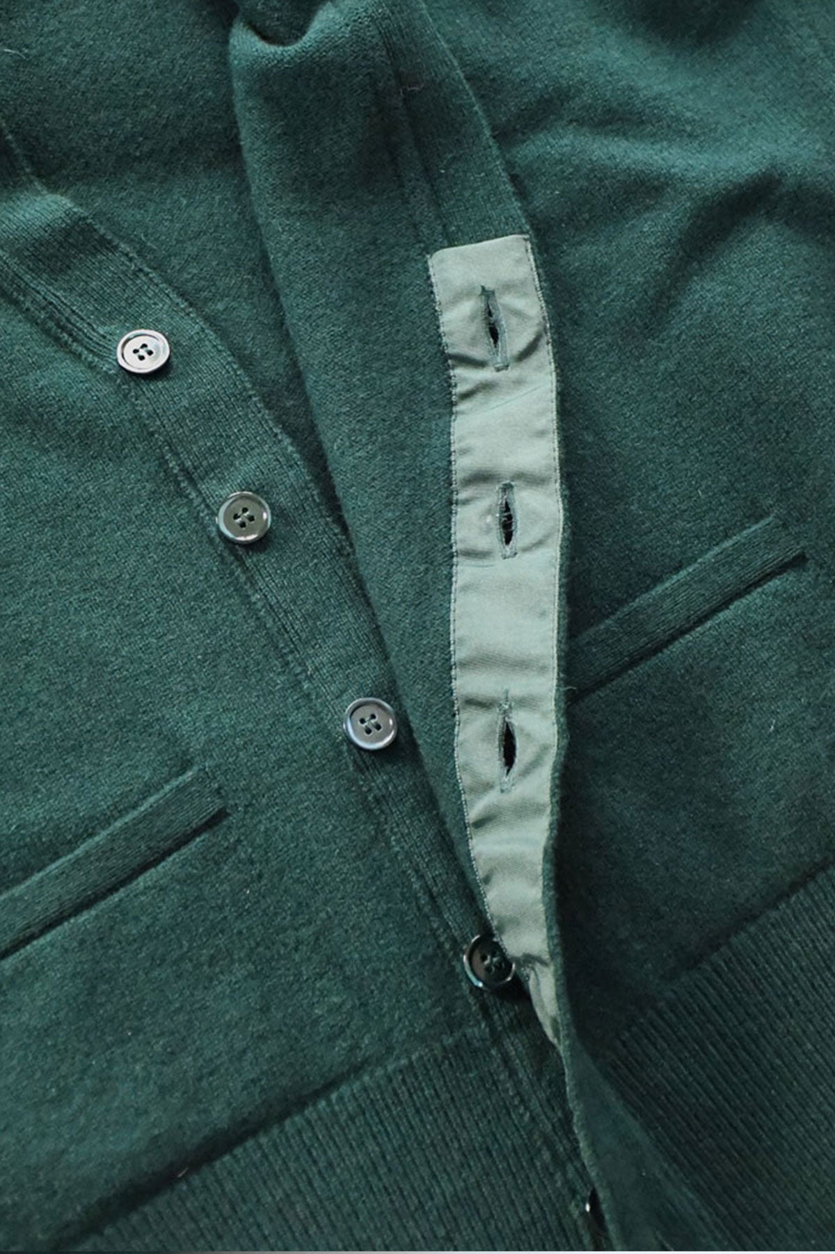 Green forest-colored wool cardigan by Ardentes Clipei, lightweight knit, short length, with a button-up front.