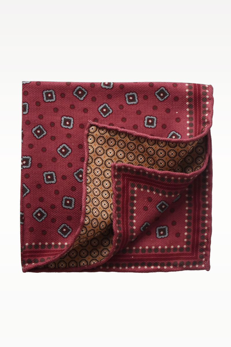 Red caramel geometric motif pochette by Ardentes Clipei, showcasing a stylish, compact accessory with bold pattern and elegant design.