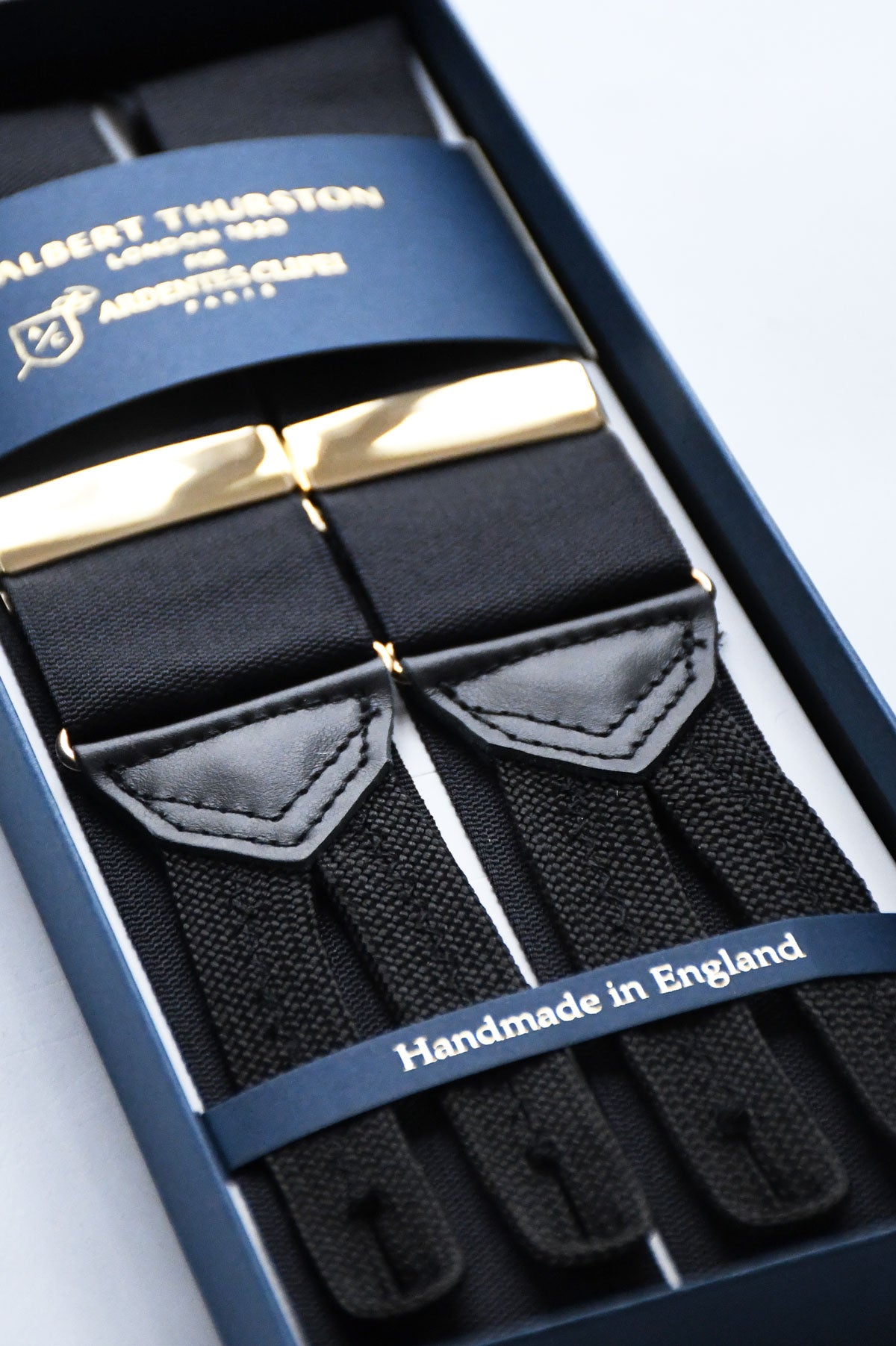Black suspenders by Albert Thurston featuring gold accents, styled as classic men's fashion accessory.