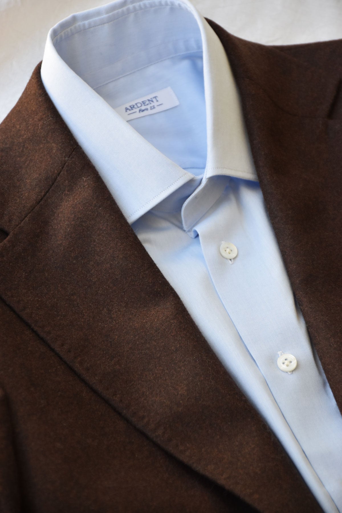 Light blue cotton twill chemise with classic collar by Ardentes Clipei, featuring a clean, tailored fit and button-front design.
