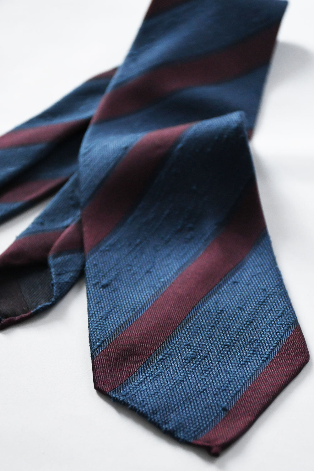 Blue denim and Bordeaux shantung club tie by Ardentes Clipei, featuring a textured fabric and classic design.