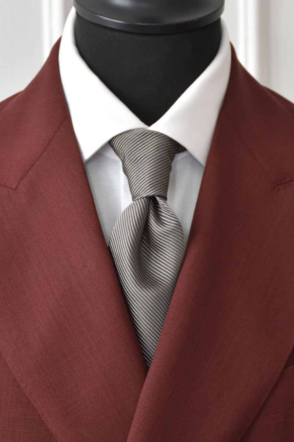 Gray silk twill tie by Ardentes Clipei featuring a marked pattern, displayed flat showing the textured fabric and detailed design.