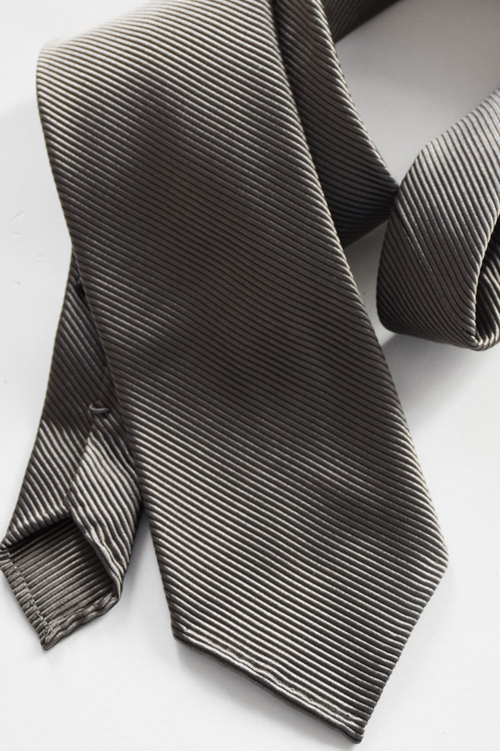 Gray silk twill tie with subtle branded markings from Ardentes Clipei, stylish and sophisticated for formal occasions.