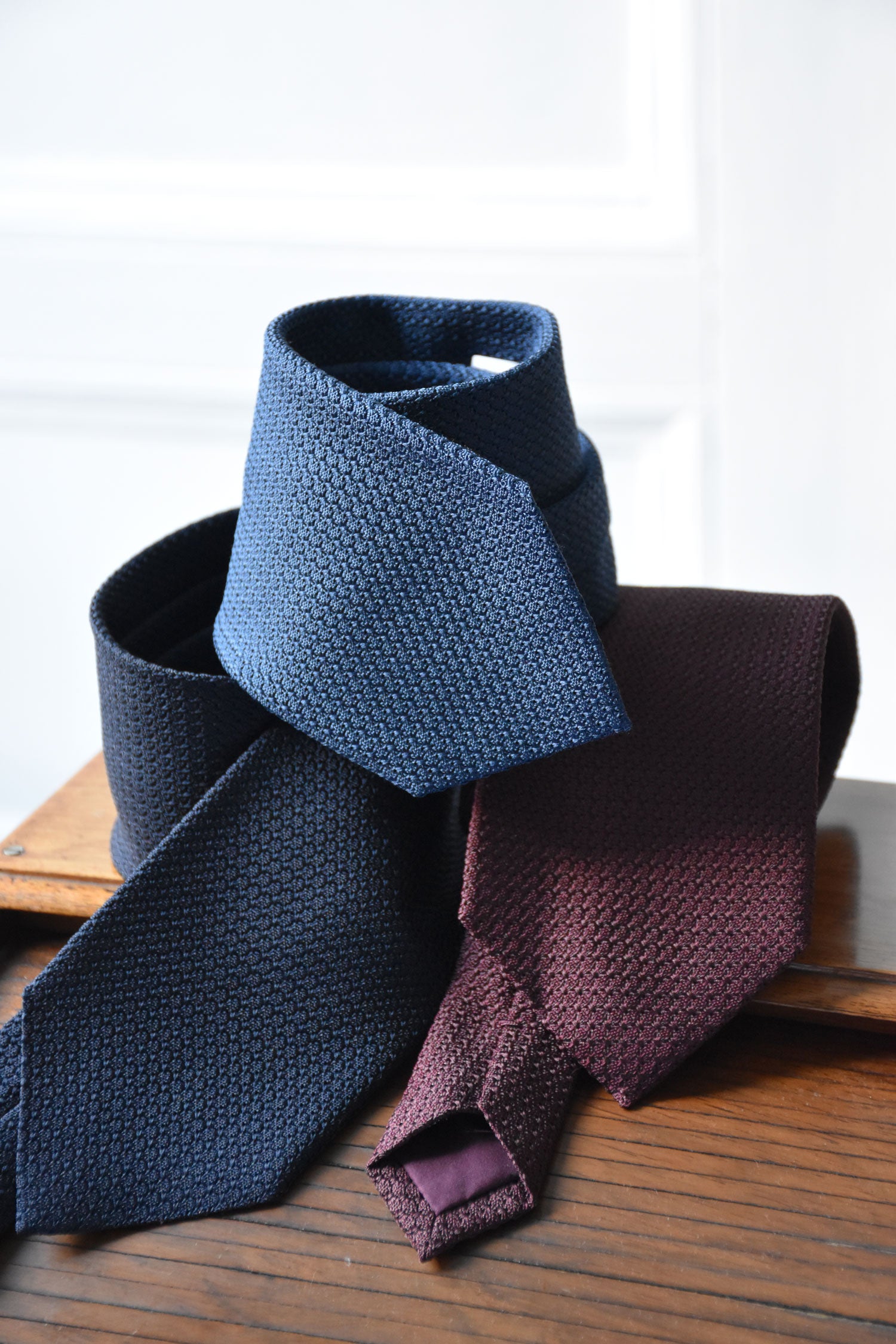 Blue denim silk grenadine tie by Ardentes Clipei, double-layered, with detailed close-up of woven fabric and elegant design.