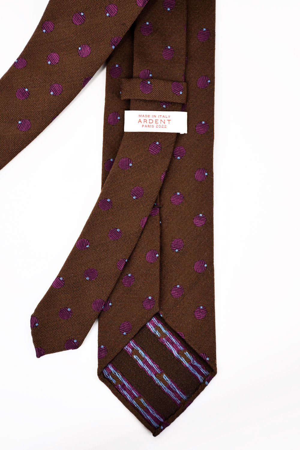 Brown textured tie with purple polka dots from Ardentes Clipei, showcasing the detailed fabric and vibrant pattern.