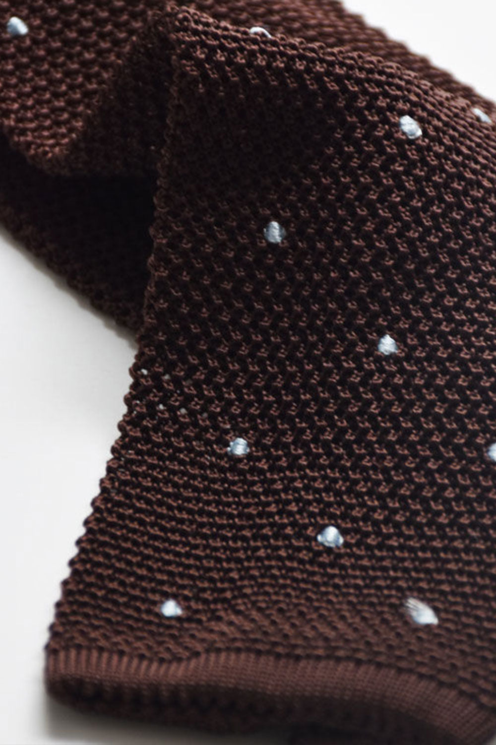 Brown knitted tie with sky blue polka dots from Ardentes Clipei, showcasing textured fabric and stylish pattern.