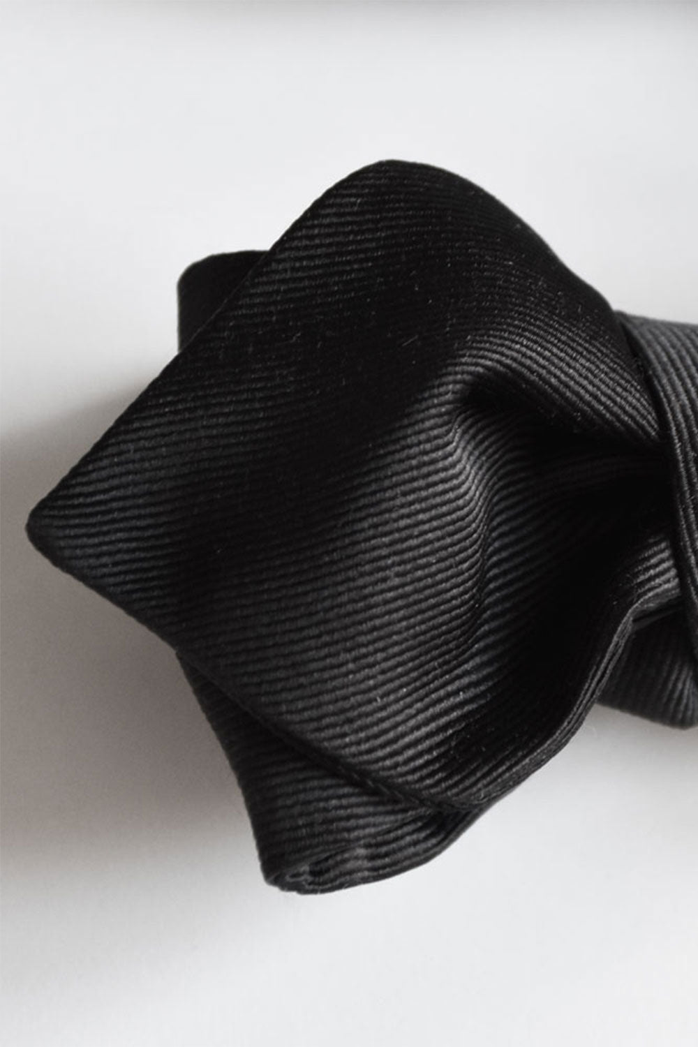 Black silk bow tie with grosgrain texture, elegant cravate by Ardentes Clipei, showcasing its refined fabric and classic design.