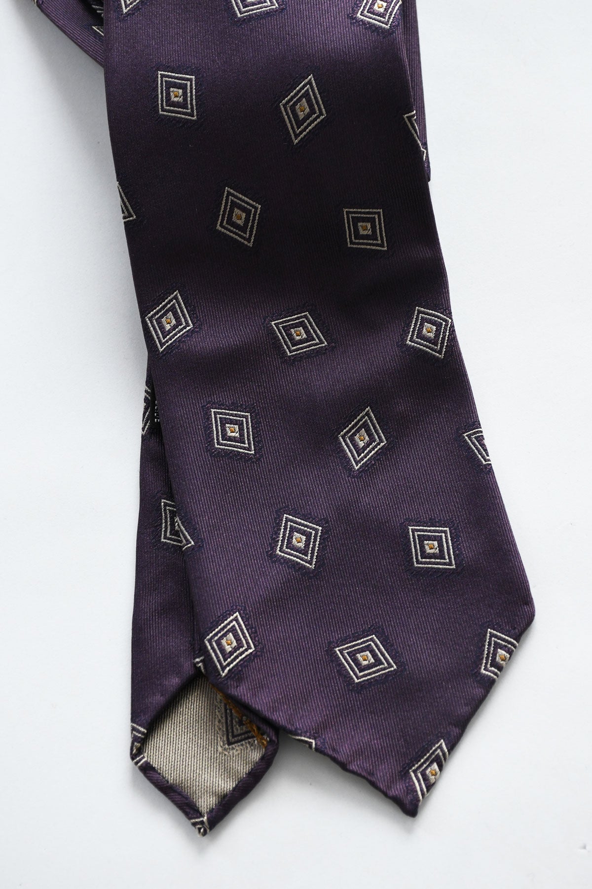 Violet silk jacquard tie with diamond pattern by Ardentes Clipei, showcasing intricate woven motifs and elegant design.