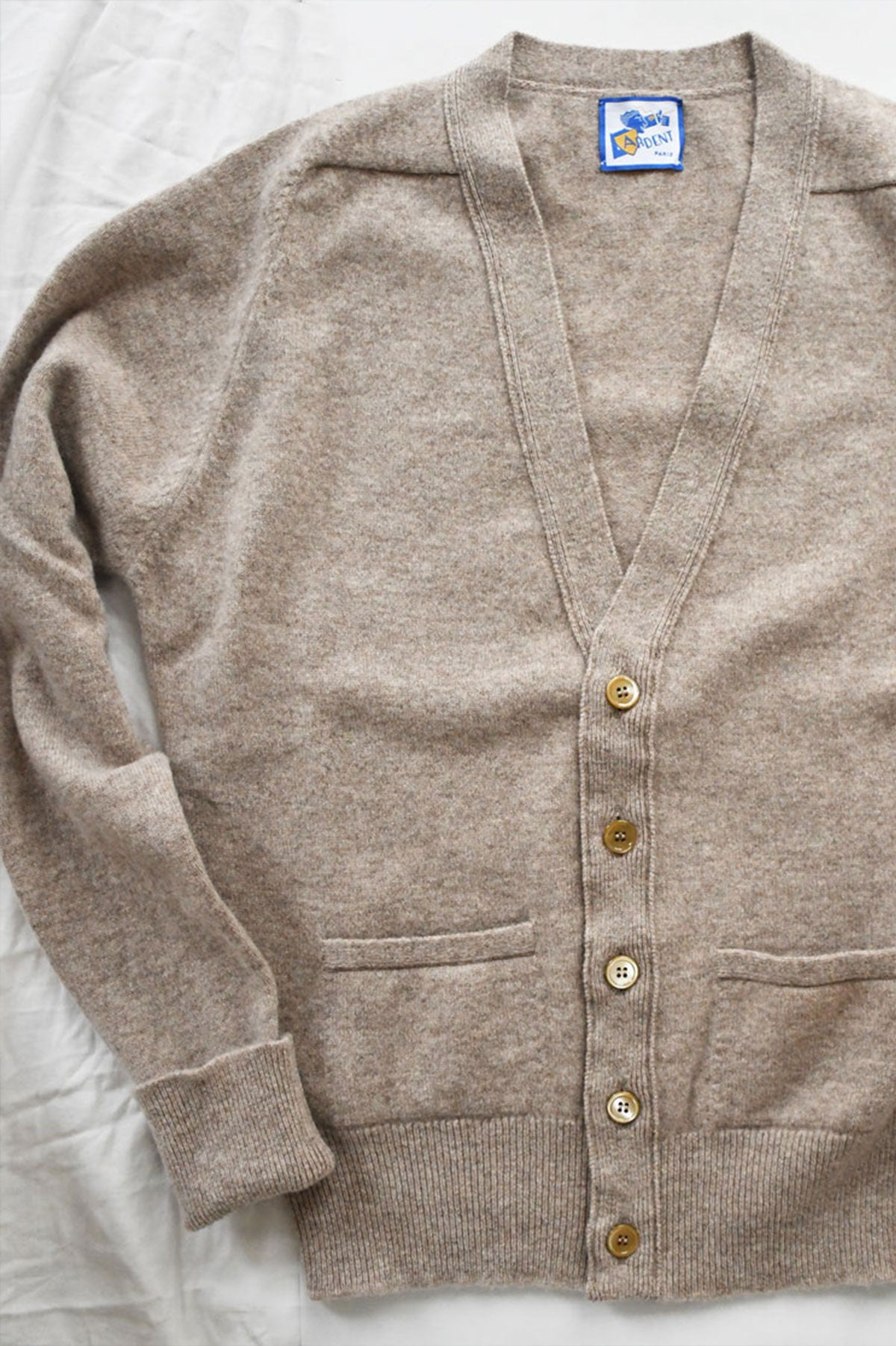 Beige Mélangé Laine d'Agneau Maille Cardigan by Ardentes Clipei, lightweight knit sweater, close-up of textured fabric and button details.