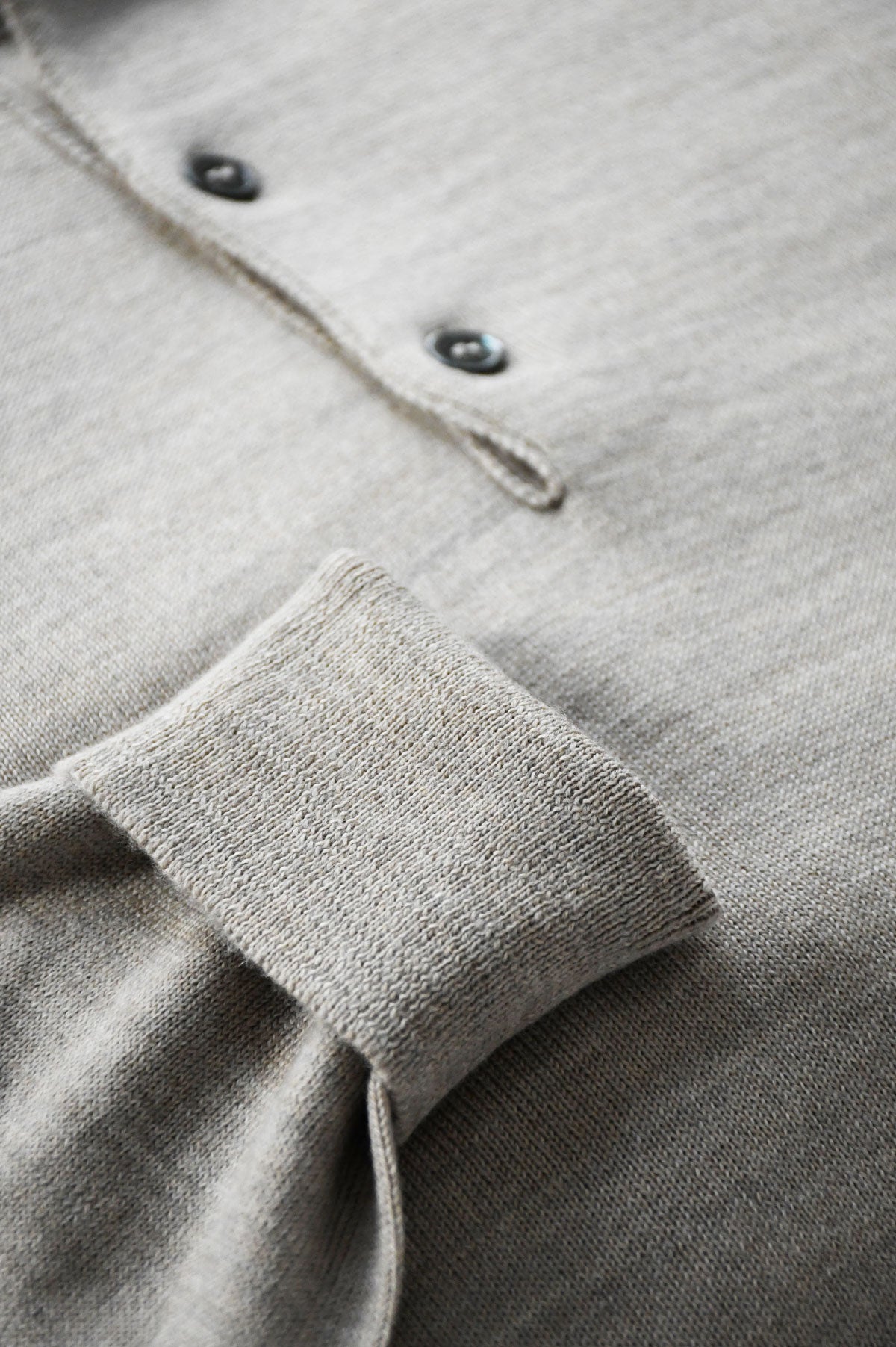 Beige mixed merino wool polo collar knit sweater by Ardentes Clipei, showing close-up of the textured fabric and collar details.