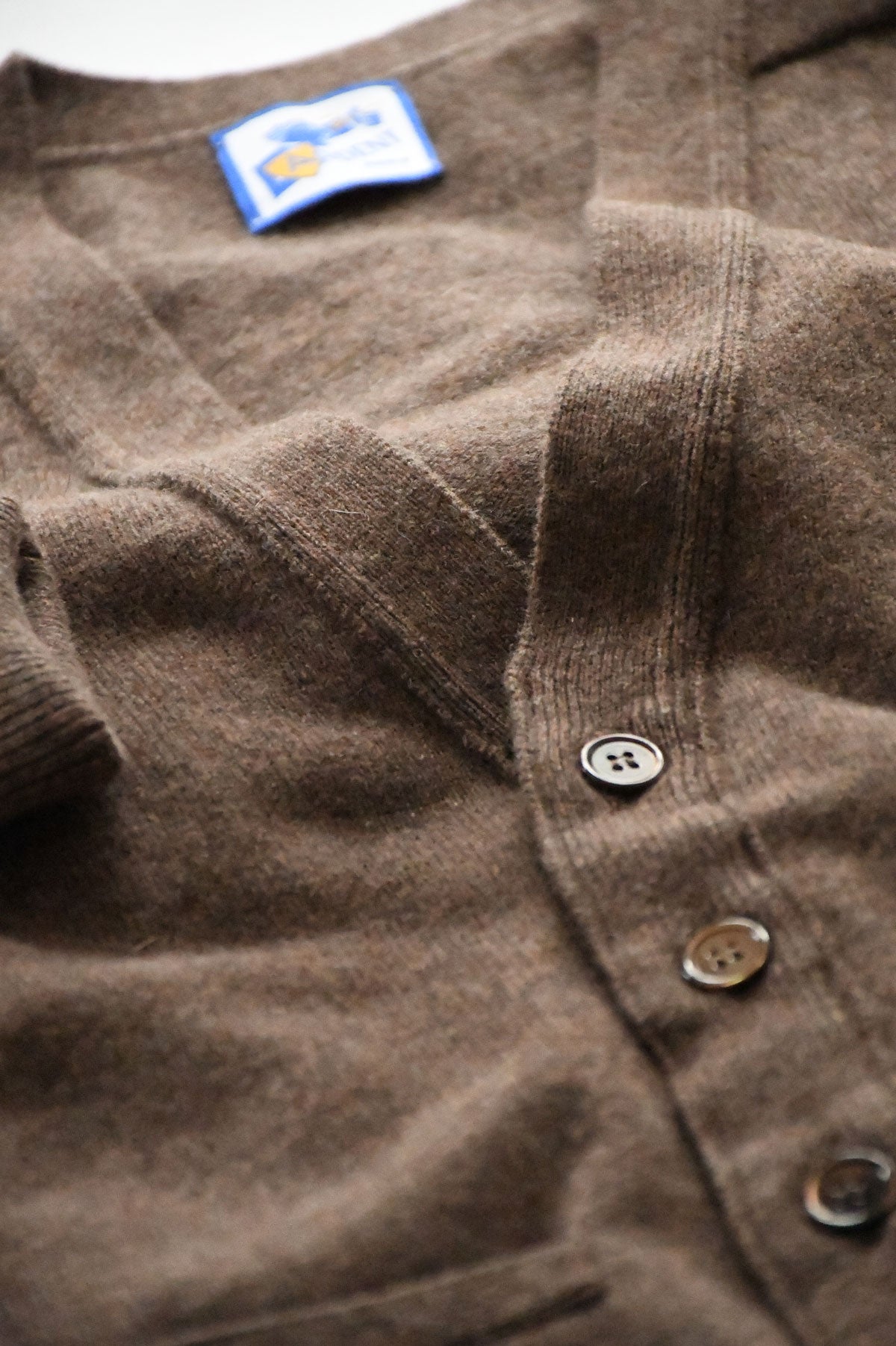 Light brown mixed wool cardigan by Ardentes Clipei, showing the soft knit fabric and button details on a model.