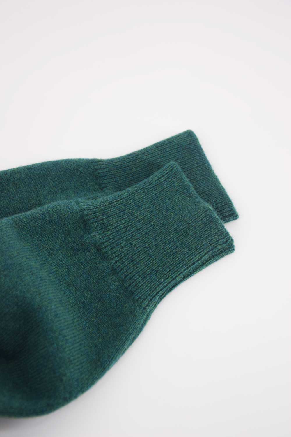 Green wool round-neck sweater by Ardentes Clipei, showing a close-up of the soft knit fabric and classic style.