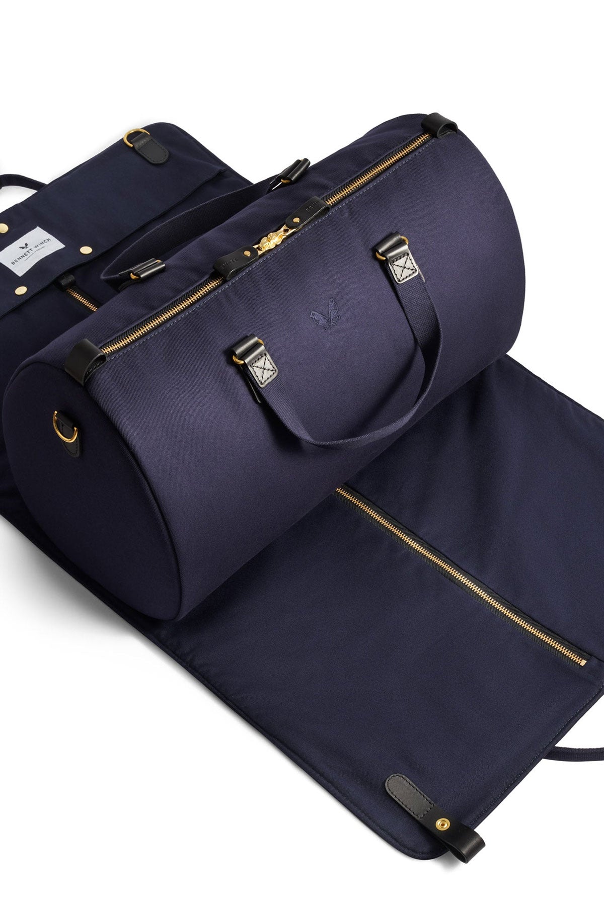 Navy blue Bennett Winch suit carrier holdall from Ardentes Clipei, showcasing durable marroquinerie design with handles and sleek shape.