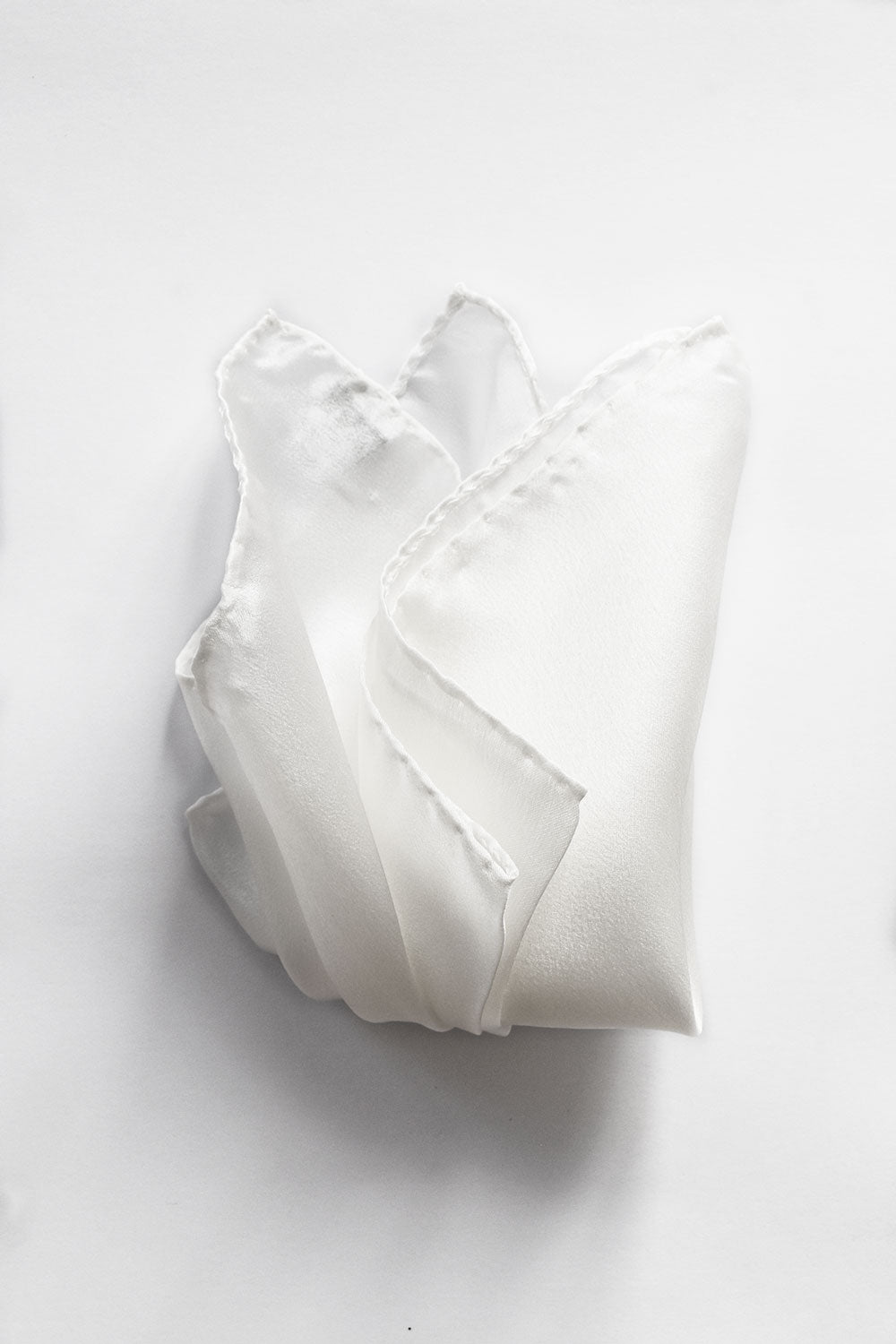 White silk pochette by Ardentes Clipei, featuring elegant, smooth fabric and simple design ideal for formal accessories.