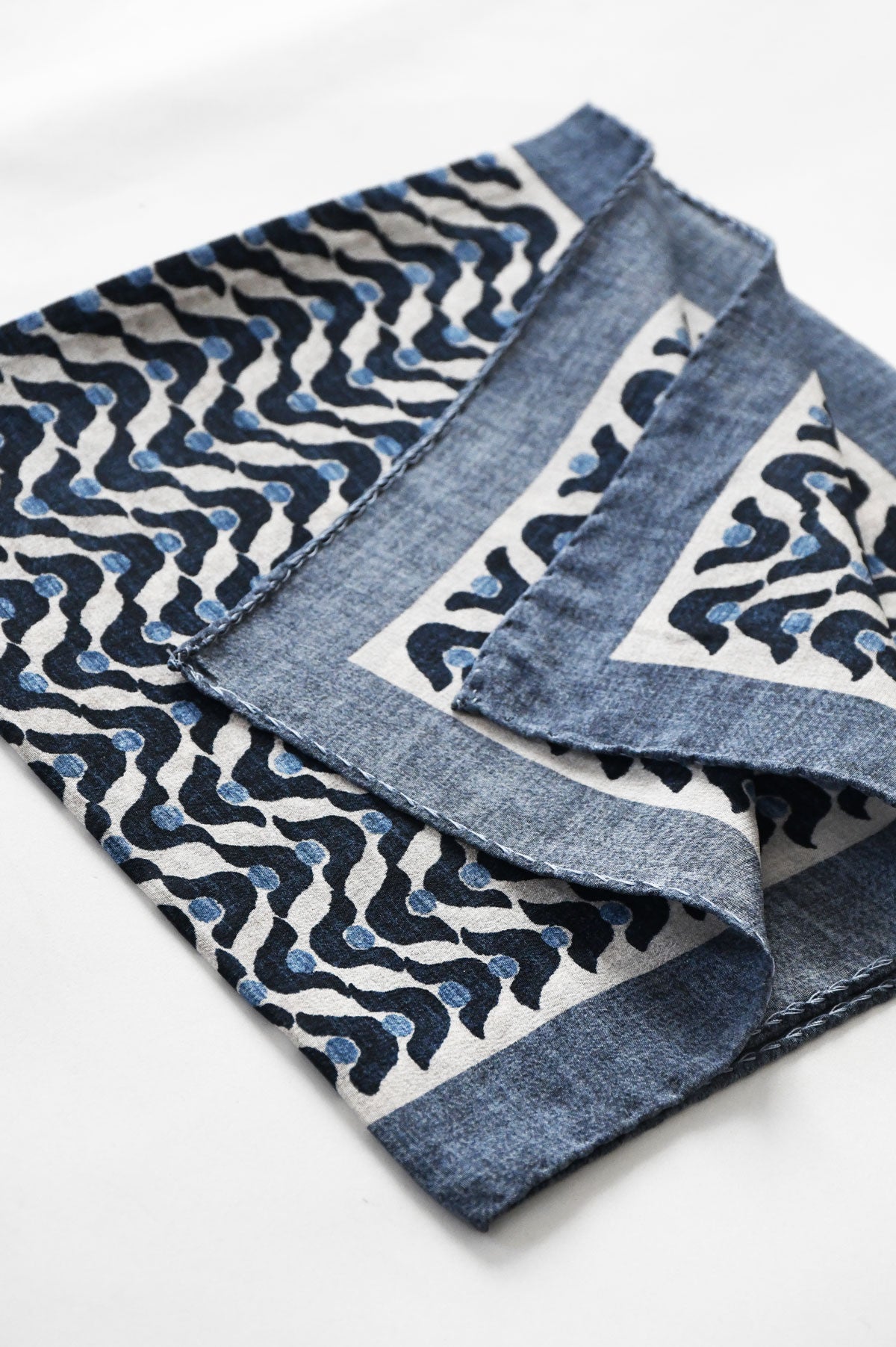 Blue denim motif pochette by Ardentes Clipei featuring a vague, artistic design on a sleek accessory for stylish occasions.