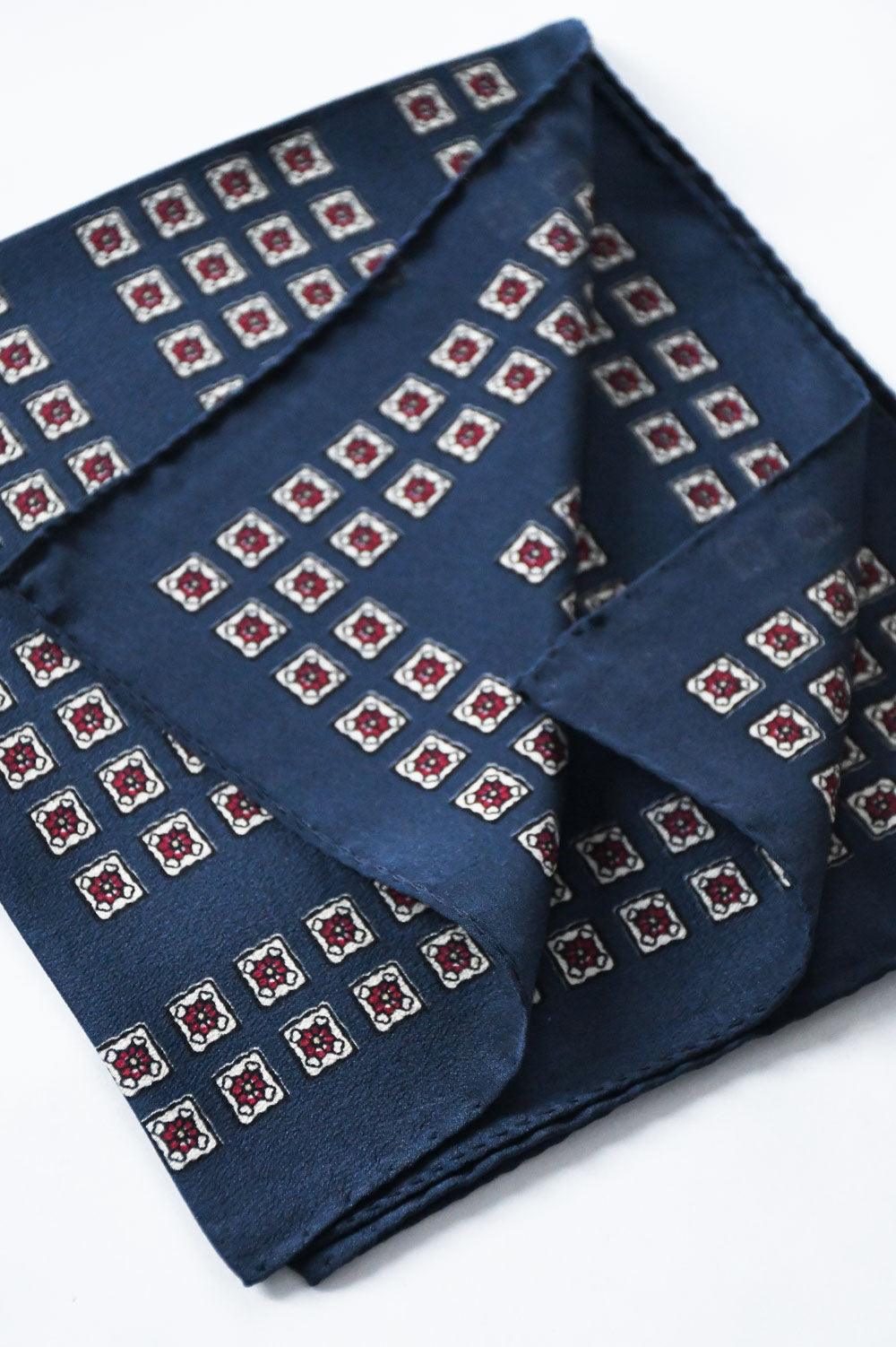 Blue marine pochette by Ardentes Clipei with geometric and floral motif, featuring a stylish and compact design.