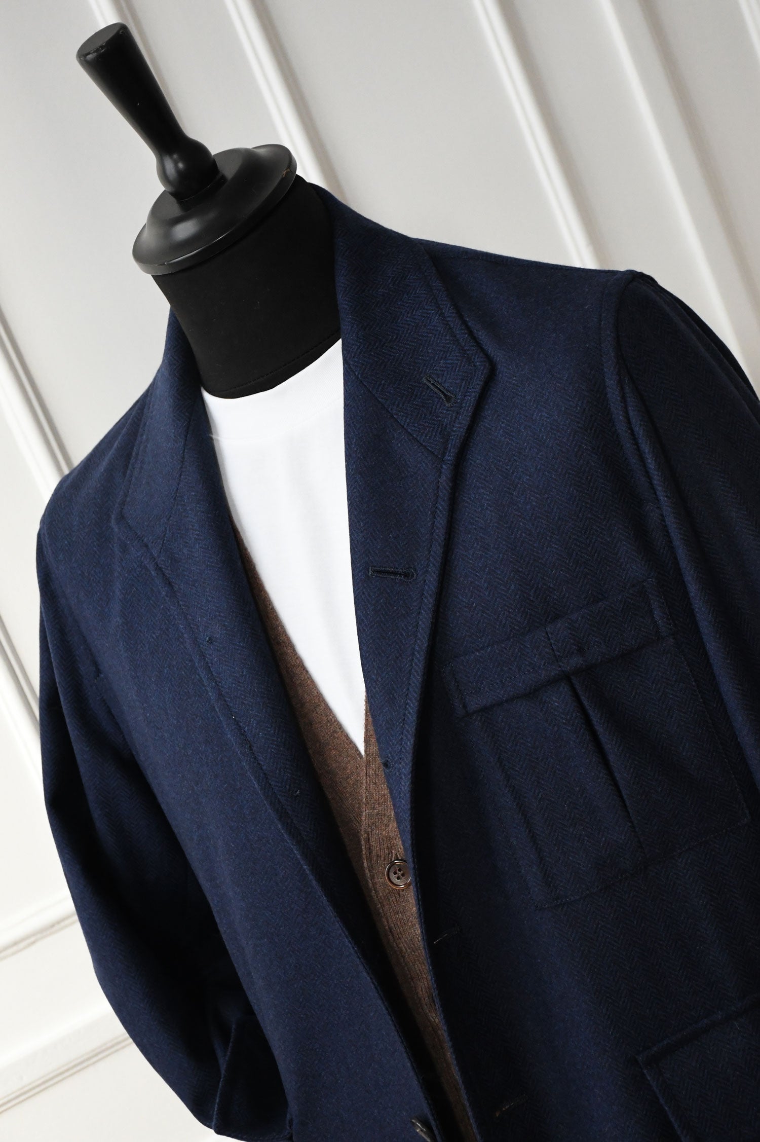 Ardentes Clipei Veste Teba Ardent in navy blue with chevron pattern, showing the tailored collar and button details.