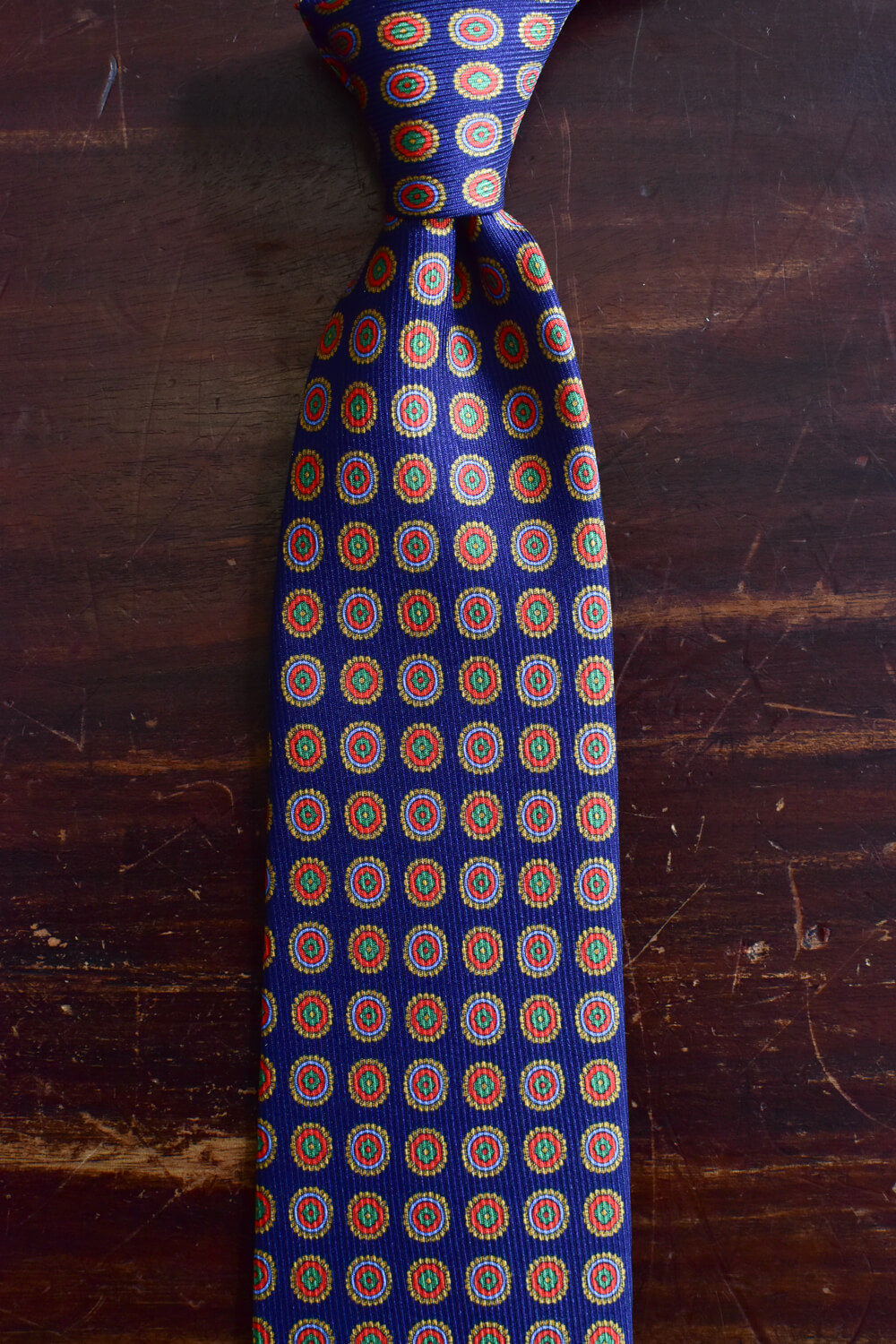Cravate bleu marine imprimé médaillon orange vert Calabrese